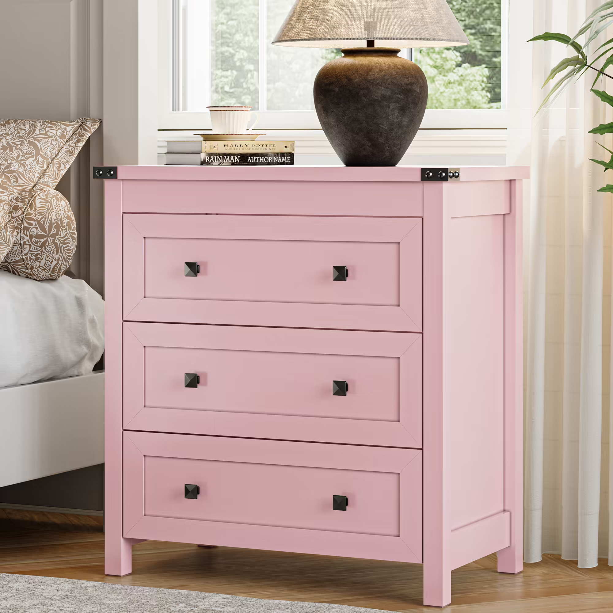 Pink farmhouse nightstand with 3 drawers styled beside bed with lamp