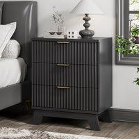 Modern black small dresser and end table used as a bedside nightstand, featuring wave-like fluted drawers and styled with coral decor.