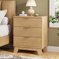 Modern natural oak small dresser and end table used as a bedside nightstand, featuring wave-like fluted drawers and styled with coral decor