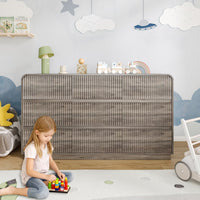 Premium 9 drawer fluted gray wood dresser decorated with charming nursery accessories