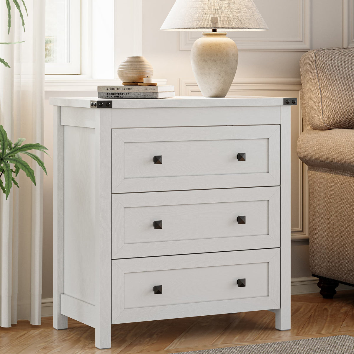 Modern farmhouse end table with 3 storage drawers placed next to sofa in living room with ceramic lamp