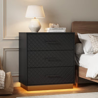 Black 3-drawer dresser with warm LED base light styled as a bedside nightstand