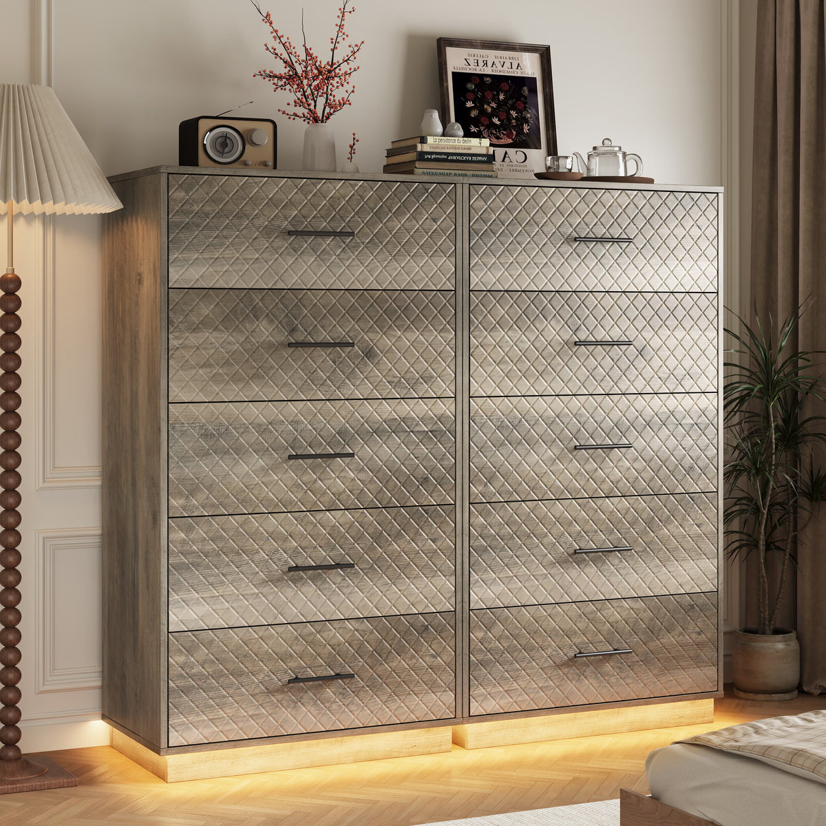 Set of two wood gray tall 5-drawer dressers with warm LED base light in a bedroom