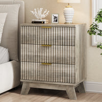 Modern gray small dresser and end table used as a bedside nightstand, featuring wave-like fluted drawers and styled with coral decor.