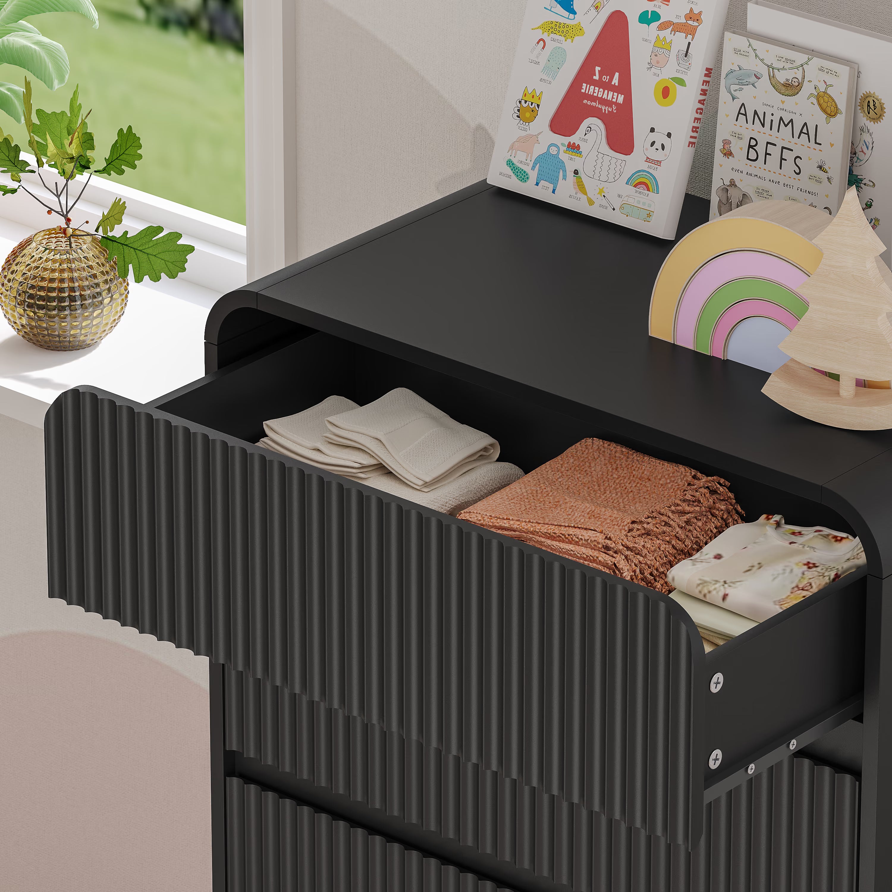 Top surface of a stylish Linea black kids dresser with smooth fluted drawer fronts and hidden handles.